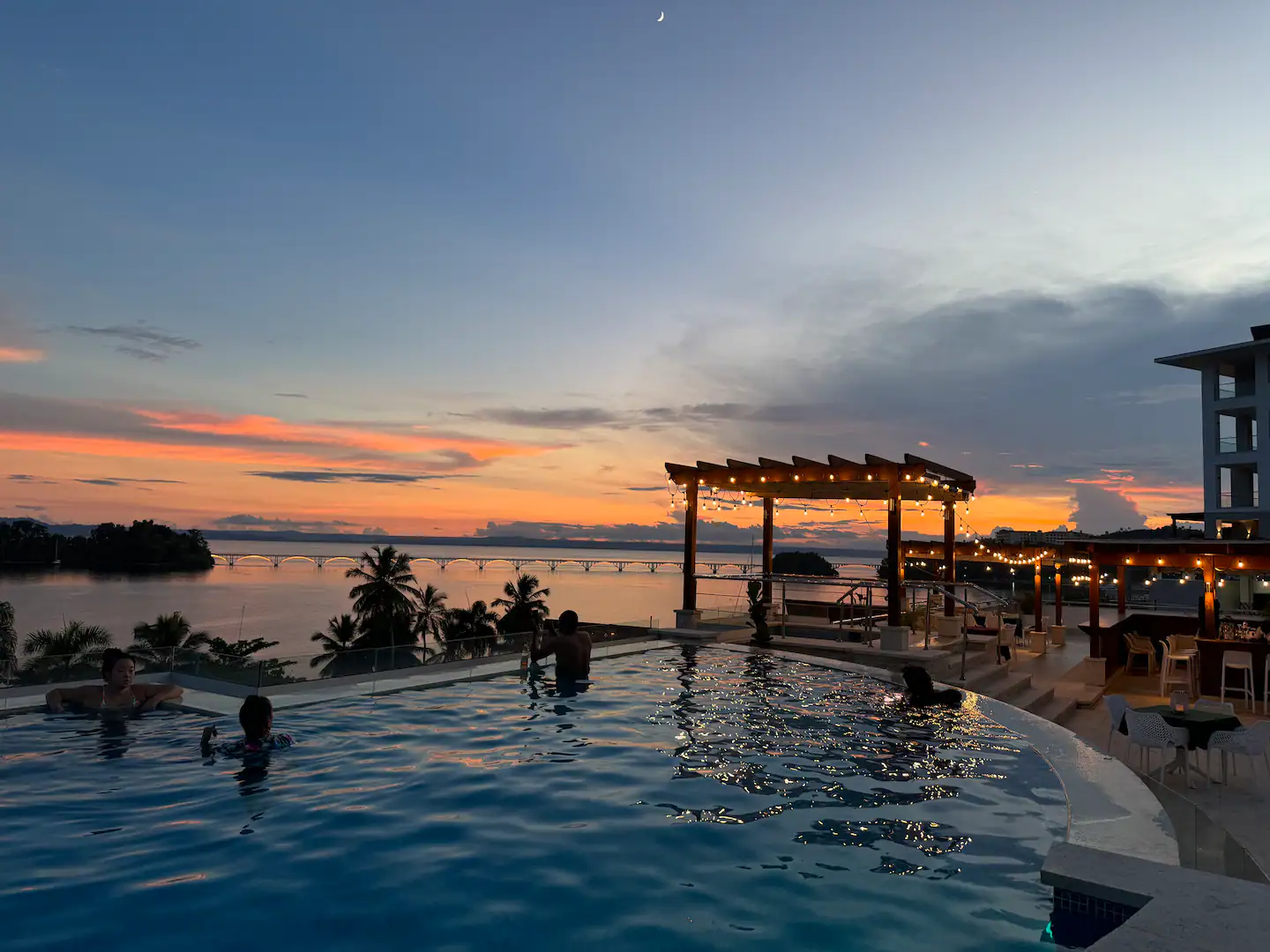 La piscina al atardecer, con la bahía detrás