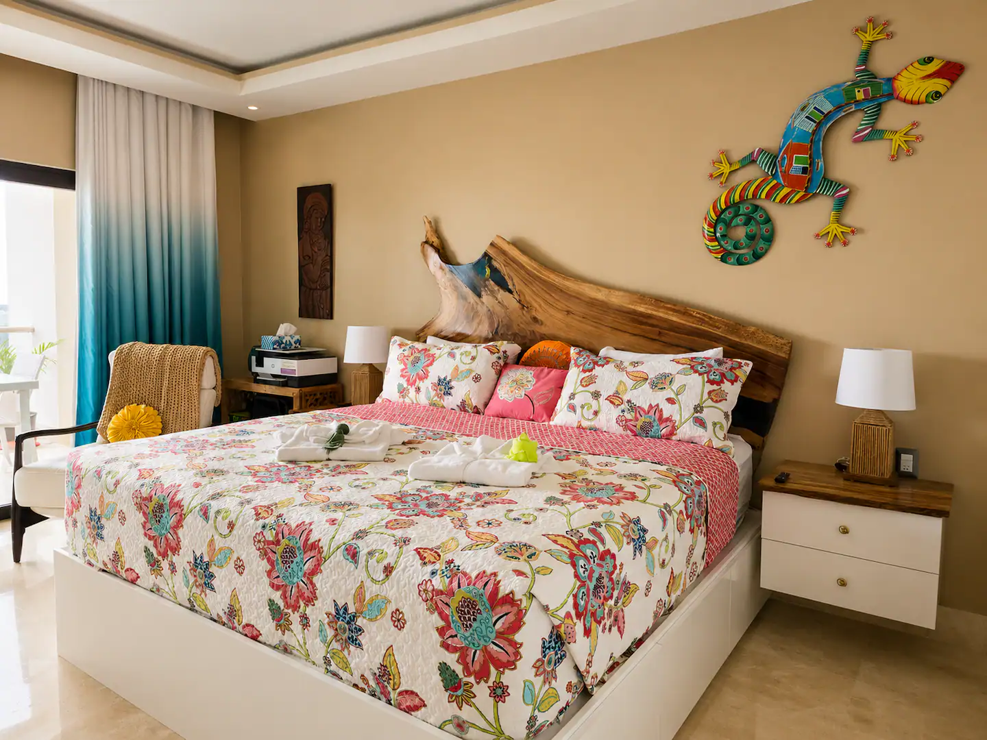 Dormitorio con cama king, ropa de cama floreada y mesitas de noche