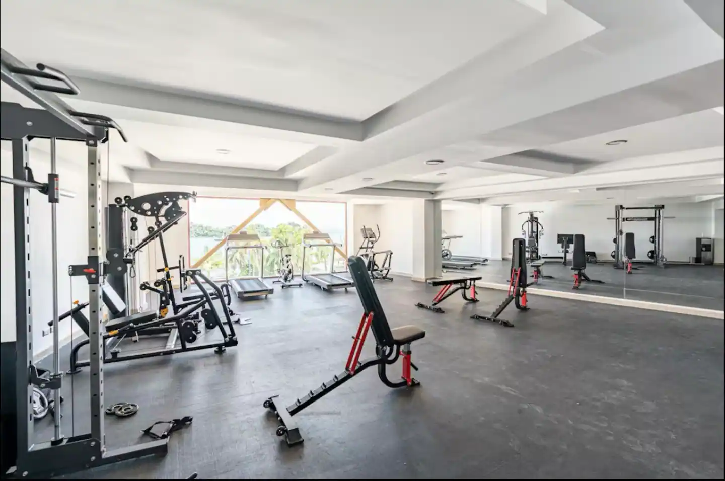 Gimnasio del complejo con máquinas y ventanales