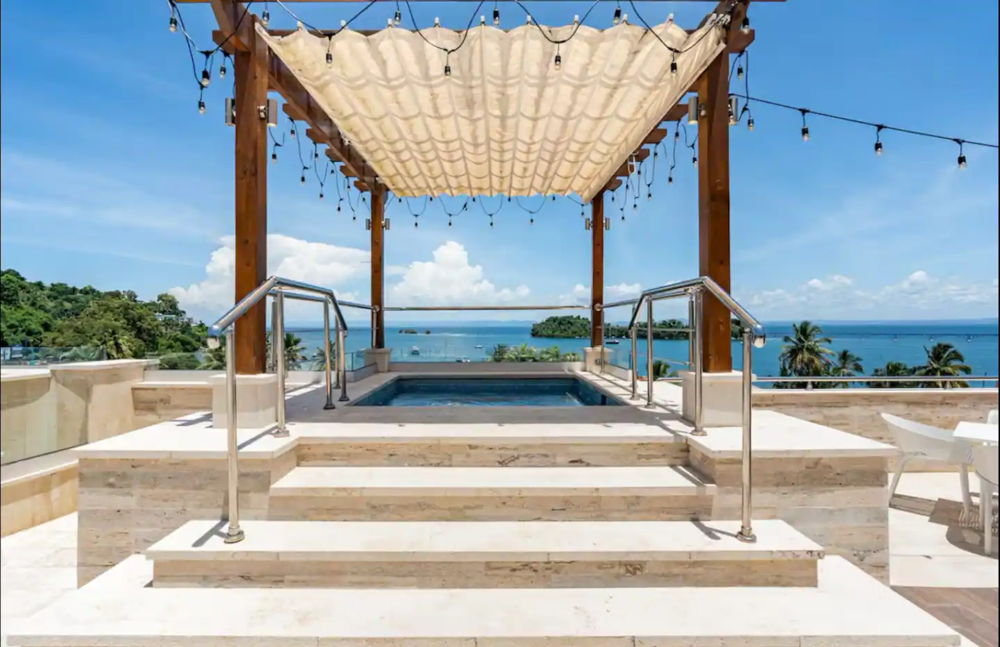 Jacuzzi bajo una pérgola de madera con luces