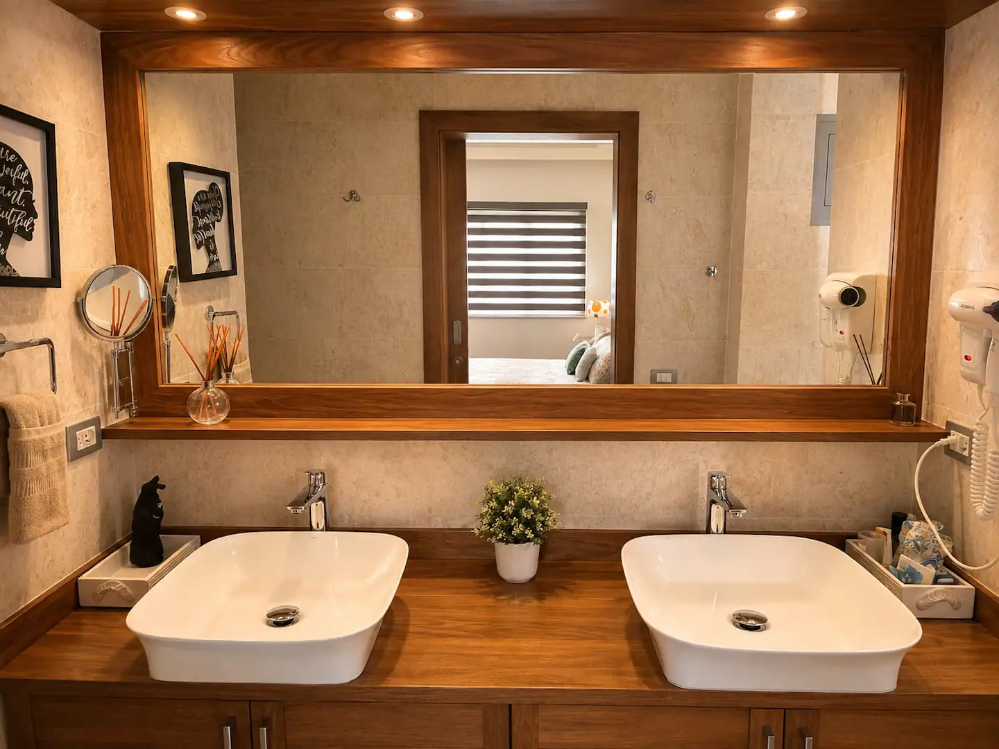 Baño con doble lavabo sobre encimera de madera y espejo grande
