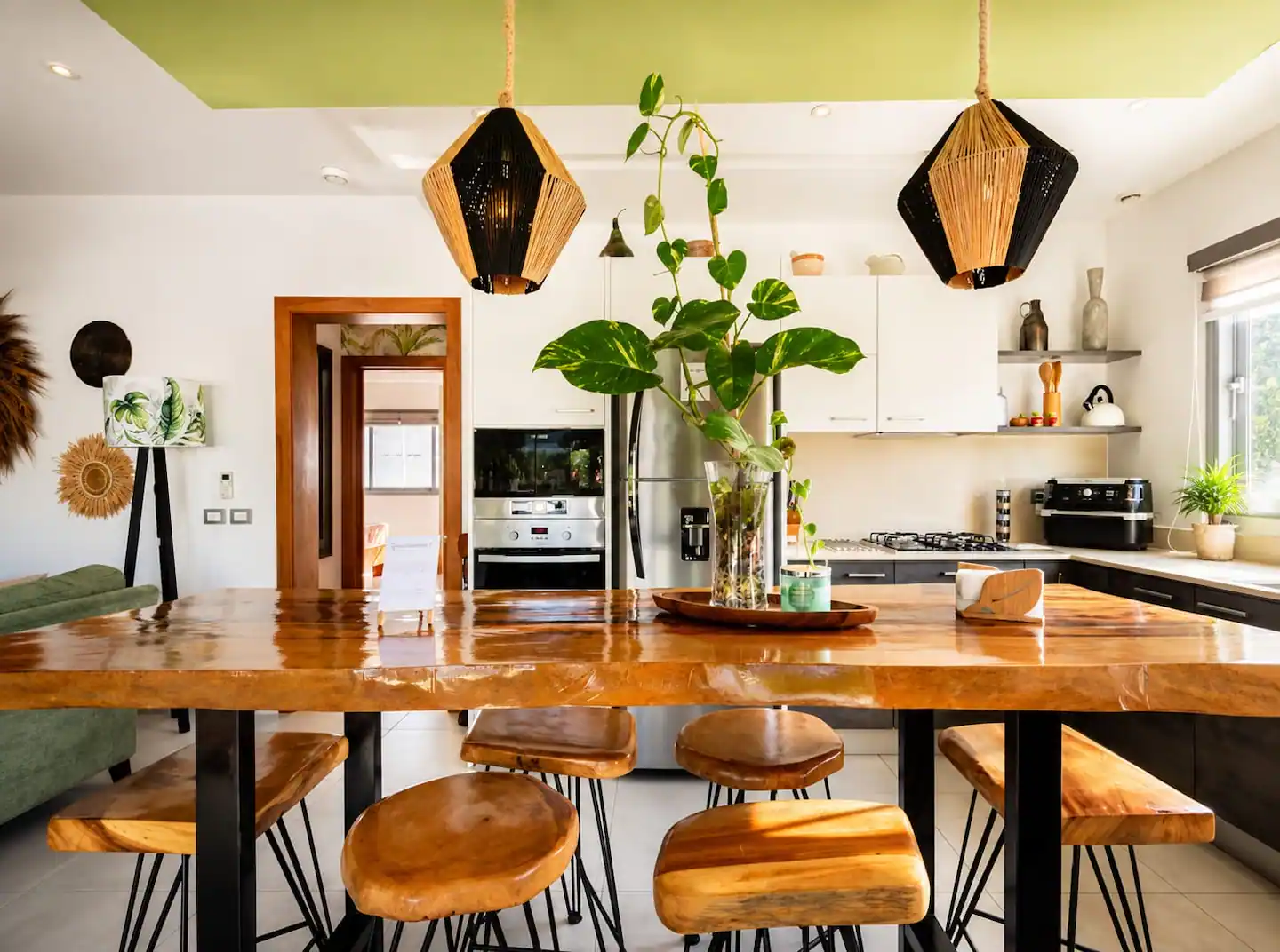 Cocina abierta con barra de madera maciza y lámparas geométricas