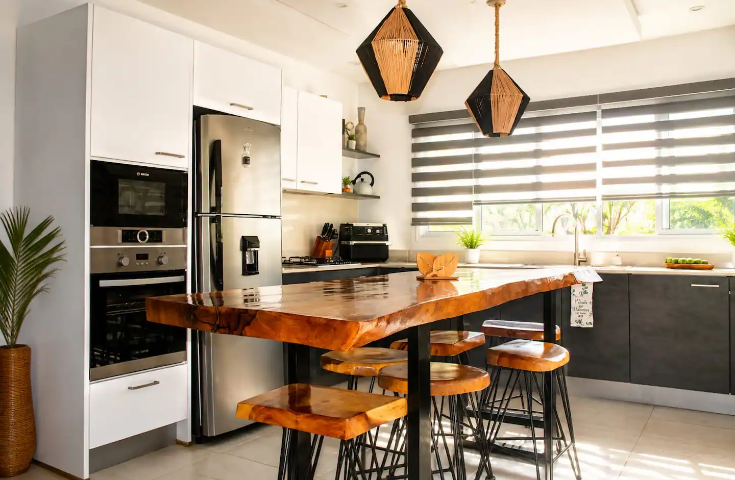Cocina con horno, nevera y taburetes de madera