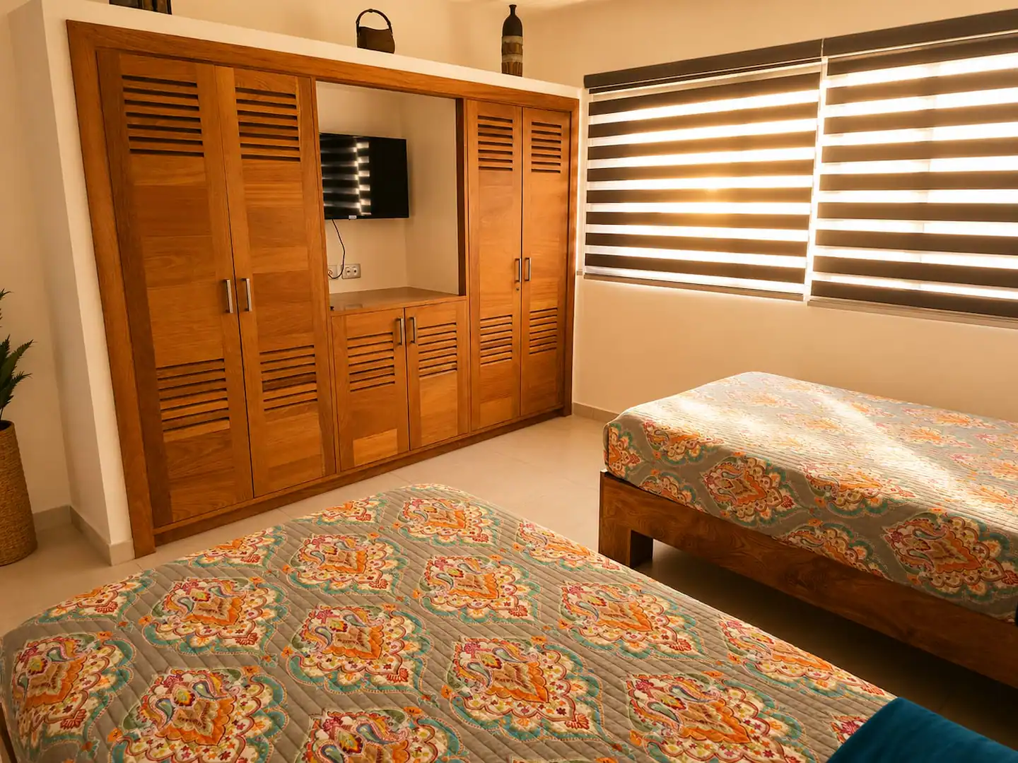 Segunda habitación con dos camas y armario de madera