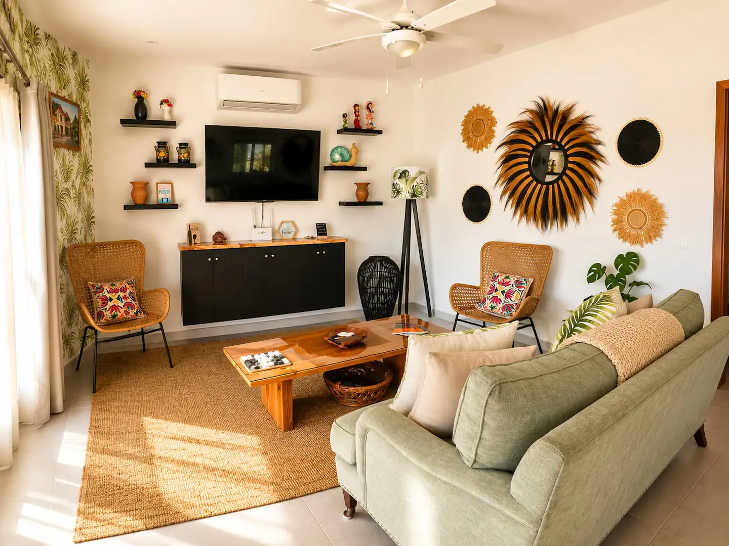 Sala con sofá verde, papel pintado tropical y televisión